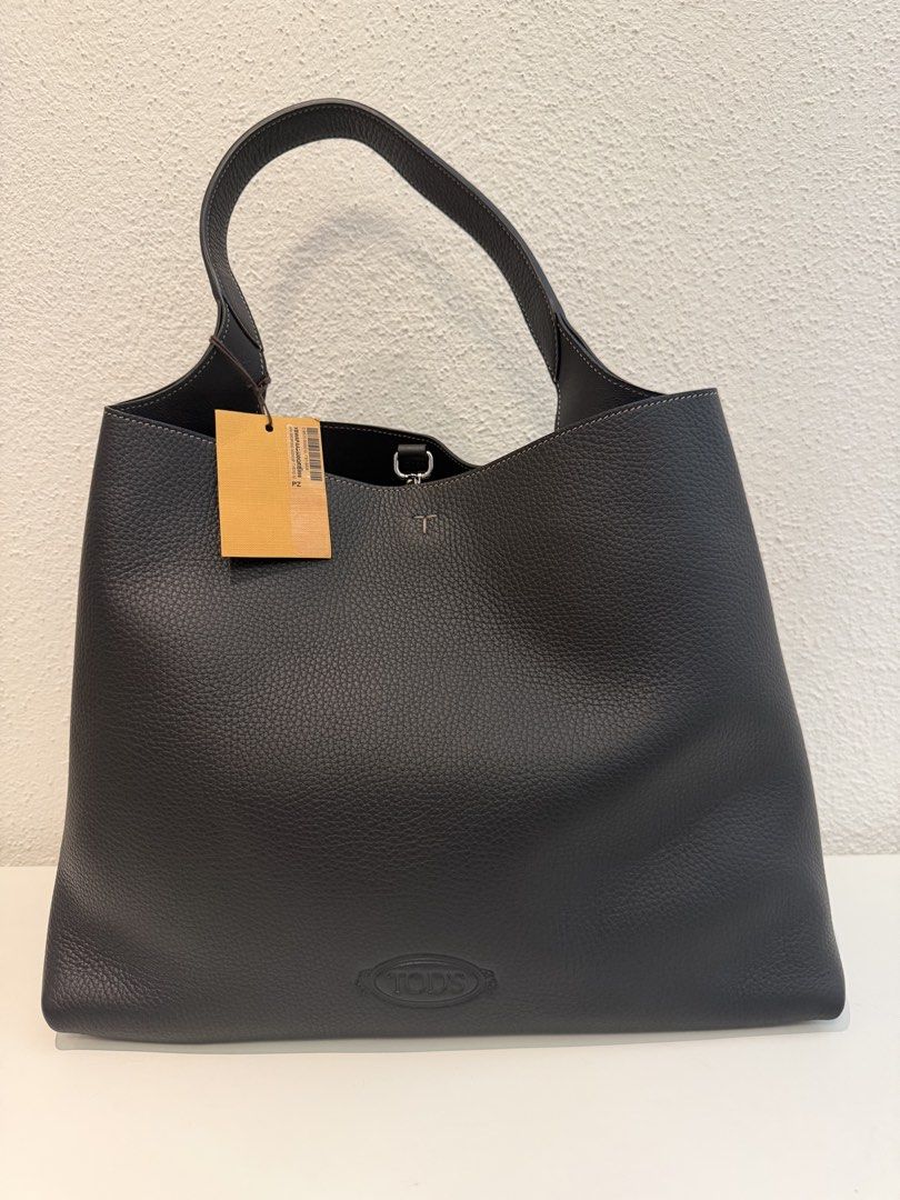 Tod’s APA Shopping Monospalla T Pend Medium (Category: Shoulder Bags) located in Pasig City. Submitted by closetofashopaholic (Listing ID 1470251253, Image 2). Description: - Brand: Tod's - Material: Premium black grained leather - Hardware: Silver-tone with metallic T charm on strap - Features: Embossed logo, structured base with 4 protective feet, clean black interior - Condition: Brand new with tag still attached, hardware charm wrapped in pla