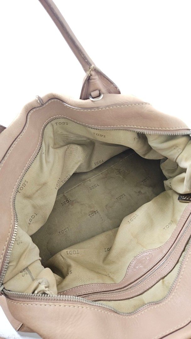 Tod's D Styling Bauletto Bag (Category: Luxury Bags & Wallets) located in Alfonso. Submitted by jbcamet (Listing ID 1470267393, Image 3). Description: - Brand: Tod's - Material: Taupe leather with fabric lining - Hardware: Silver-tone with branded metal side closure - Features: Double top handles, protective bottom feet, interior serial number tag - Condition Notes: Exterior has scuffs and wear from use; interior fabric lining shows notable dirt 