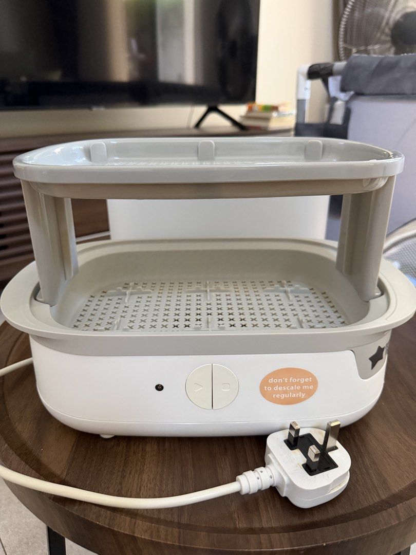 Tommee Tippee Electric Bottle Steriliser (Category: Breastfeeding & Bottle Feeding) located in Taguig. Submitted by enabee (Listing ID 1470213338, Image 2). Description: - Brand: Tommee Tippee Electric Steam Steriliser - Condition: Clean and well-maintained heating plate - Includes: Base unit, transparent cover, two-tier rack, and tongs - Features: Simple one-button operation, side reminder sticker, and bottom cable wrap - Plug type: Standard UK 
