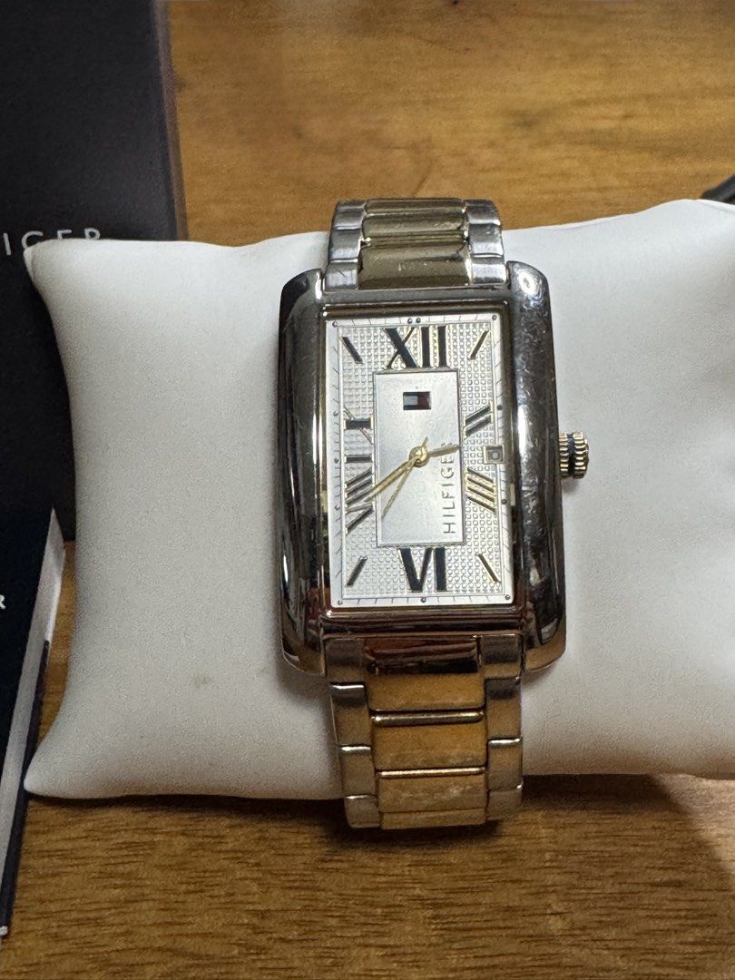 Tommy Hilfiger Rectangular Two-Tone Watch with Box and Manual (Category: Women's Watches) located in Valenzuela. Submitted by wisetree_18aeb6 (Listing ID 1470206872, Image 2). Description: - Brand: Tommy Hilfiger - Design: Rectangular case with a textured white dial, Roman numerals, and date display - Strap: Two-tone silver and gold metal bracelet with a deployment clasp - Details: Gold crown, elegant and classic everyday wear - Inclusions: Origi