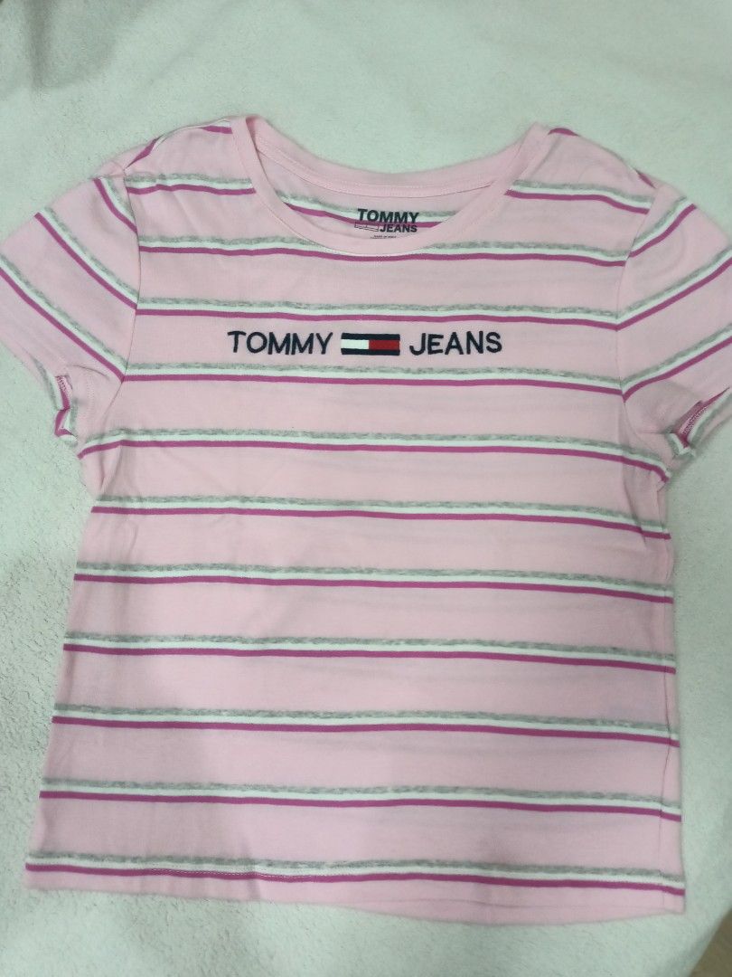 Tommy Jeans Pink Striped Tee Size L (Category: Shirts) located in Manila. Submitted by jollynest24 (Listing ID 1470282475, Image 1). Description: - Brand: Tommy Jeans - Colorway: Pink, white, and grey stripes - Size: L / G - Design: Classic crew neck, short sleeves, and embroidered chest logo - Origin: Made in India - Location : Sampaloc Manila - Gcash ( MOP).