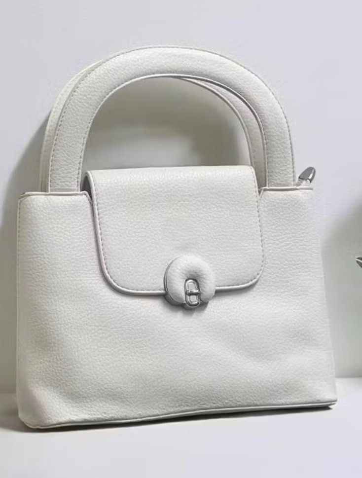 Top Handle Handbag with Crossbody Strap (Category: Shoulder Bags) located in Bulacan. Submitted by tytoluxe (Listing ID 1470208332, Image 2). Description: - Premium pebbled texture material with clean lines - Secure flap closure featuring a chic silver-tone turn-lock clasp - Includes a matching adjustable long strap for shoulder or crossbody wear - Features a sturdy, rounded top handle for comfortable hand carrying - Versatile solid color design 