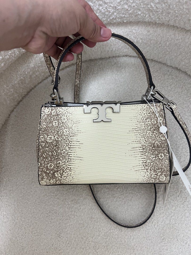 Tory Burch Eleanor Top Handle Bag (Category: Cross-body Bags) located in Abulug. Submitted by jamiecammie (Listing ID 1470273503, Image 1). Description: - Brand: Tory Burch - Design: Cream and brown snakeskin print with silver hardware and iconic T logo clasp - Versatility: Includes a top handle and a matching adjustable crossbody strap - Interior: Clean white lining with a convenient card pocket slot - Protection: Bottom features four metal feet