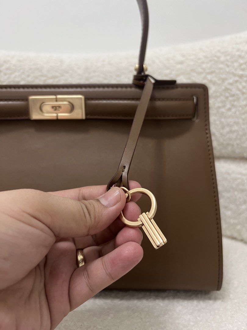 Tory Burch Lee Radziwill Bag (Category: Shoulder Bags) located in Abulug. Submitted by jamiecammie (Listing ID 1470273904, Image 3). Description: - Brand: Tory Burch - Color: Rich brown leather with premium gold hardware - Structure: Structured shape with sturdy top handle and protective bottom studs - Versatility: Includes a detachable shoulder strap for crossbody or hand carry .