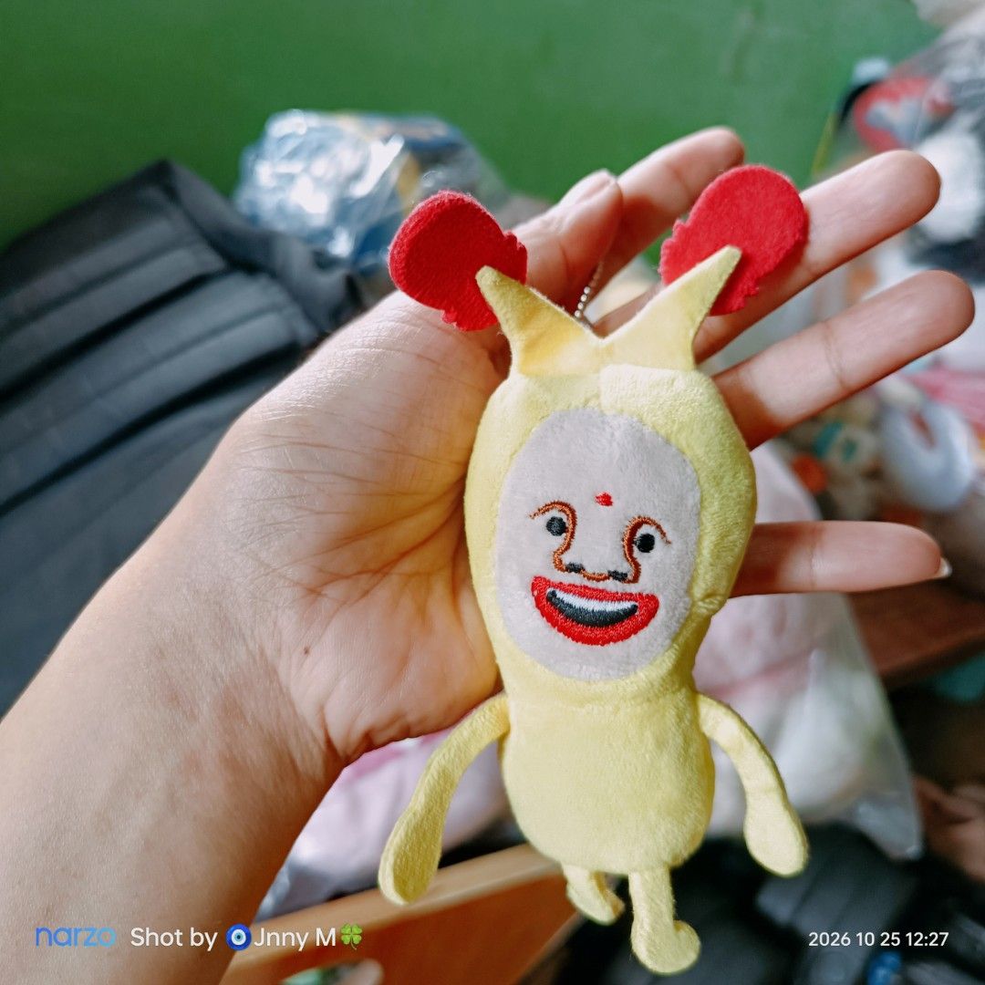 Toshitaka Nabata Yellow Character Plush Keychain (Category: Plushies & Soft Toys) located in Taguig. Submitted by mhayestufftoys (Listing ID 1470190710, Image 1). Description: - Official Toshitaka Nabata designer plush keychain - Features a quirky character with embroidered face, red mouth, and red antennae horns - Equipped with a sturdy metal ball chain for easy hanging on bags, pouches, or keys - Includes original artist copyright tag on the si