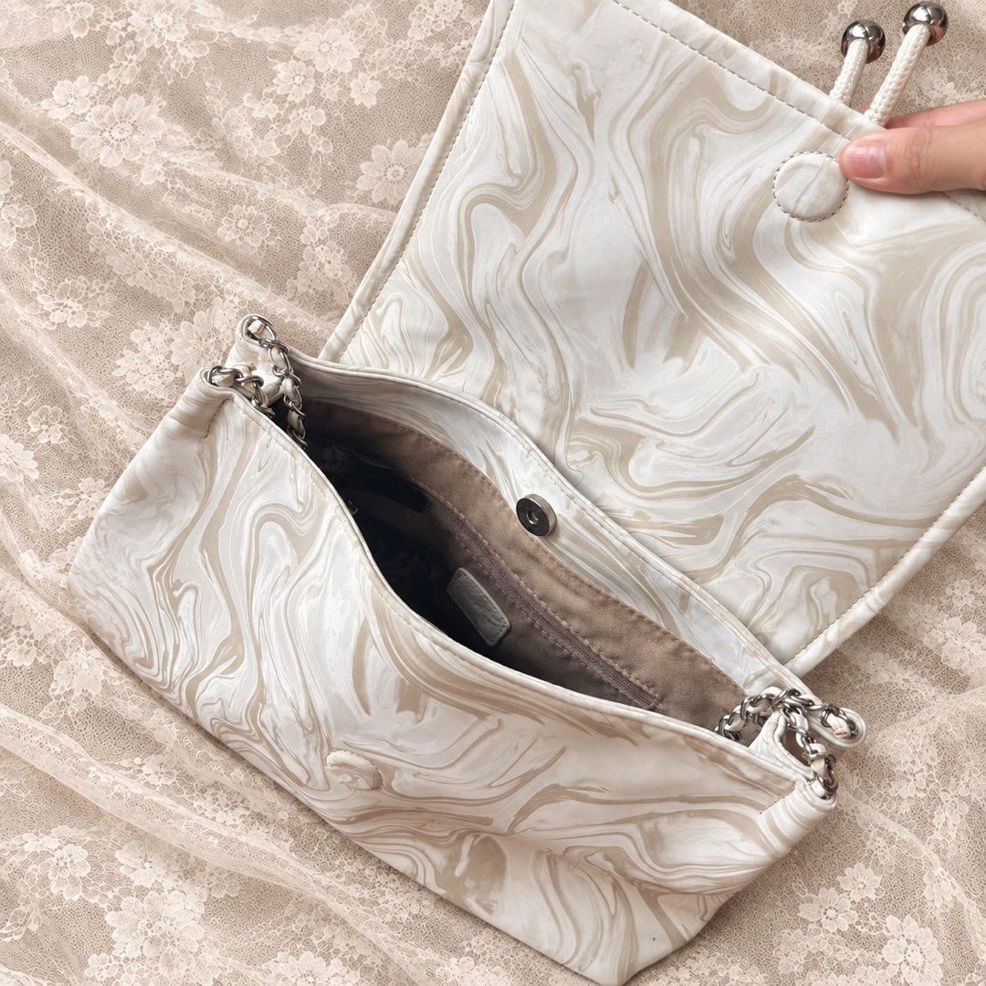 Tou Marble Print Shoulder Bag with Chain Strap (Category: Shoulder Bags) located in Manila. Submitted by calliope777 (Listing ID 1470213855, Image 3). Description: - Brand: Tou - Design: Cream and beige marble pattern with silver-tone hardware and front logo plate - Straps: Comfortable double shoulder straps with a stylish decorative chain detail - Closure & Interior: Secure magnetic closure with a fabric-lined interior and handy zippered pocket 