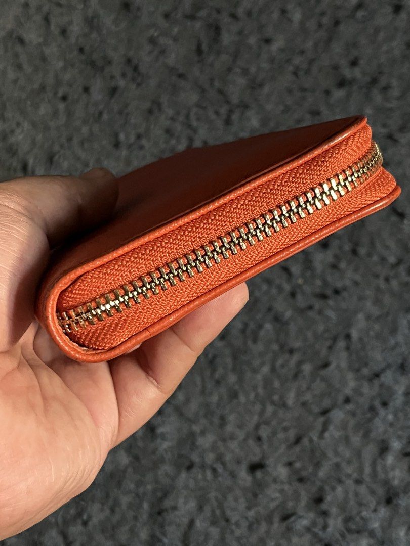 Tuscan's Orange Zip-Around Long Wallet (Category: Wallets & Card holders) located in Manila. Submitted by guyfromnowhere9 (Listing ID 1470224311, Image 3). Description: - Brand: Tuscan's - Color: Vibrant orange - Material: Textured Saffiano leather - Hardware: Gold-tone with engraved zip puller and front embossed logo - Closure: Full zip-around for maximum security - Design: Clean stitching, compact everyday size that fits easily in most handbags
