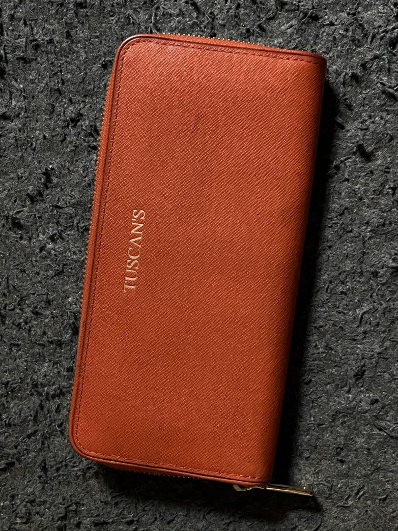 Tuscan's Orange Zip-Around Long Wallet (Category: Wallets & Card holders) located in Manila. Submitted by guyfromnowhere9 (Listing ID 1470224311, Image 2). Description: - Brand: Tuscan's - Color: Vibrant orange - Material: Textured Saffiano leather - Hardware: Gold-tone with engraved zip puller and front embossed logo - Closure: Full zip-around for maximum security - Design: Clean stitching, compact everyday size that fits easily in most handbags