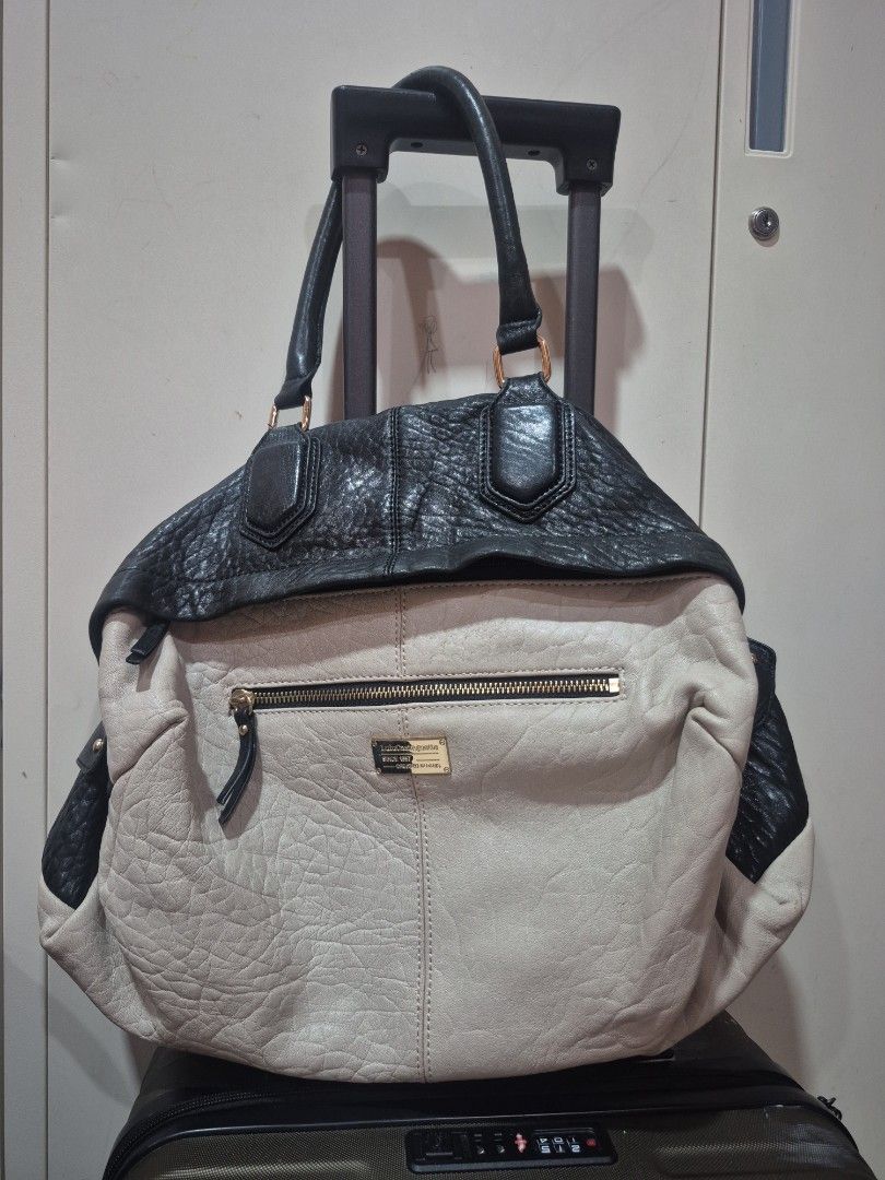Two-tone Black and Cream Leather Handbag (Category: Luxury Bags & Wallets) located in Iloilo. Submitted by gorgeoustatz (Listing ID 1470281782, Image 1). Description: - Color: Classic black and off-white color-block design - Material: Premium textured leather with gold-tone hardware - Storage: Roomy main compartment and zippered exterior front pocket with metallic brand plaque - Details: Dual rolled handles with rectangular ring attachments and s