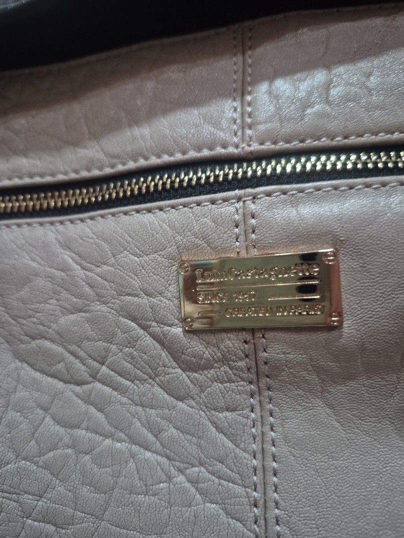 Two-tone Black and Cream Leather Handbag (Category: Luxury Bags & Wallets) located in Iloilo. Submitted by gorgeoustatz (Listing ID 1470281782, Image 2). Description: - Color: Classic black and off-white color-block design - Material: Premium textured leather with gold-tone hardware - Storage: Roomy main compartment and zippered exterior front pocket with metallic brand plaque - Details: Dual rolled handles with rectangular ring attachments and s