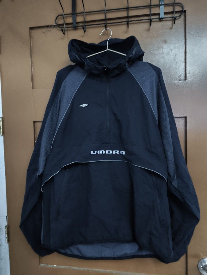 Umbro Quarter-Zip Hooded windbreaker (Category: Coats, Jackets and Outerwear) located in San Pedro. Submitted by madvillainkicks (Listing ID 1470152944, Image 2). Description: Black Umbro quarter-zip hooded windbreaker with grey textured shoulder panels and piping details. Big Umbro branding printed across the front pocket flap. Kangaroo pocket with side zips. Lightweight fabric, good for outdoor workouts or casual wear. Clean interior collar and