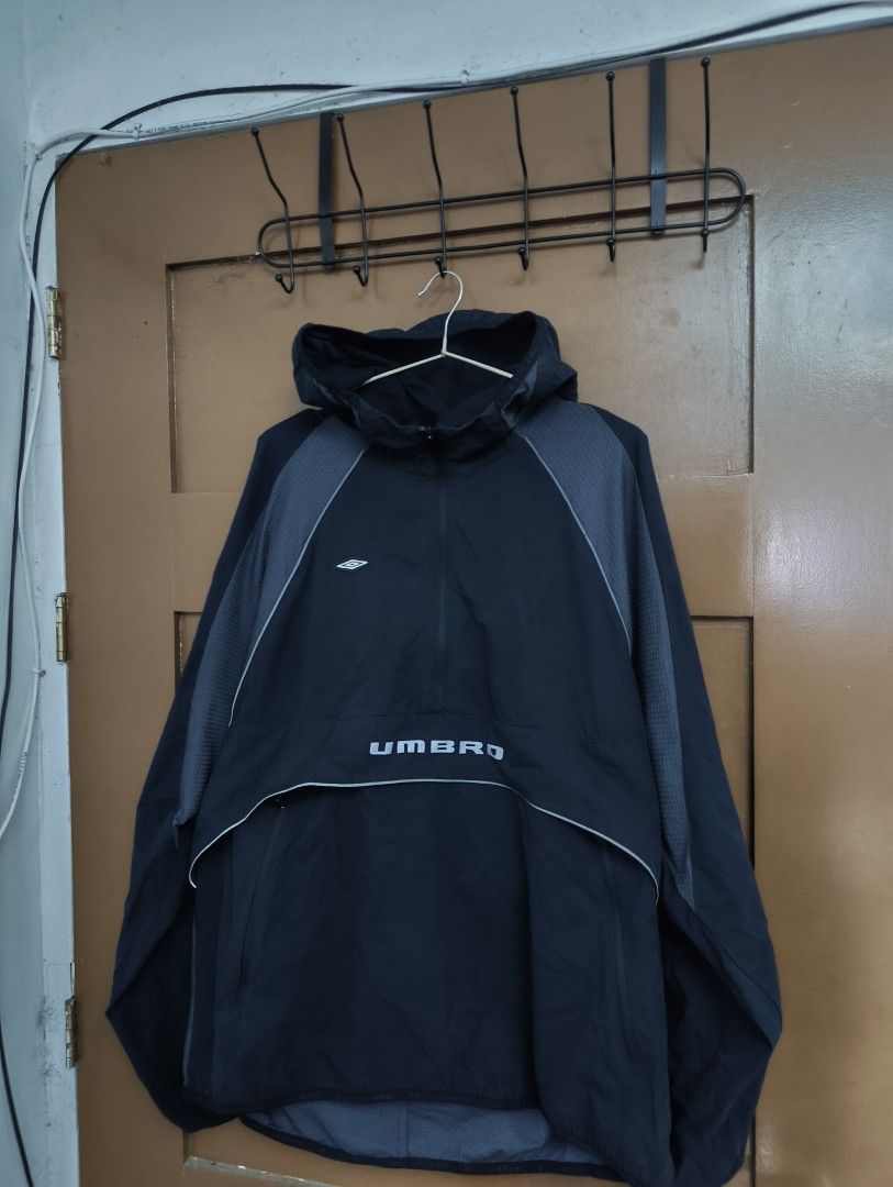 Umbro Quarter-Zip Hooded windbreaker (Category: Coats, Jackets and Outerwear) located in San Pedro. Submitted by madvillainkicks (Listing ID 1470152944, Image 1). Description: Black Umbro quarter-zip hooded windbreaker with grey textured shoulder panels and piping details. Big Umbro branding printed across the front pocket flap. Kangaroo pocket with side zips. Lightweight fabric, good for outdoor workouts or casual wear. Clean interior collar and