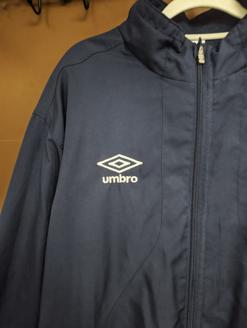 Umbro Vintage Track Jacket (Category: Coats, Jackets and Outerwear) located in San Pedro. Submitted by madvillainkicks (Listing ID 1470152333, Image 2). Description: 25 x 28 supreme umbro alternative Navy blue Umbro track jacket. Full zip front, high collar. White embroidered diamond logo on the chest. Classic retro piece, tailored by in England tag on the inside collar. Mesh inner lining. Ribbed cuffs and hem. Clean look, easy layering piece..