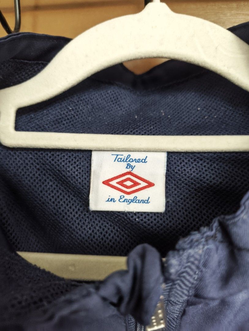 Umbro Vintage Track Jacket (Category: Coats, Jackets and Outerwear) located in San Pedro. Submitted by madvillainkicks (Listing ID 1470152333, Image 3). Description: 25 x 28 supreme umbro alternative Navy blue Umbro track jacket. Full zip front, high collar. White embroidered diamond logo on the chest. Classic retro piece, tailored by in England tag on the inside collar. Mesh inner lining. Ribbed cuffs and hem. Clean look, easy layering piece..