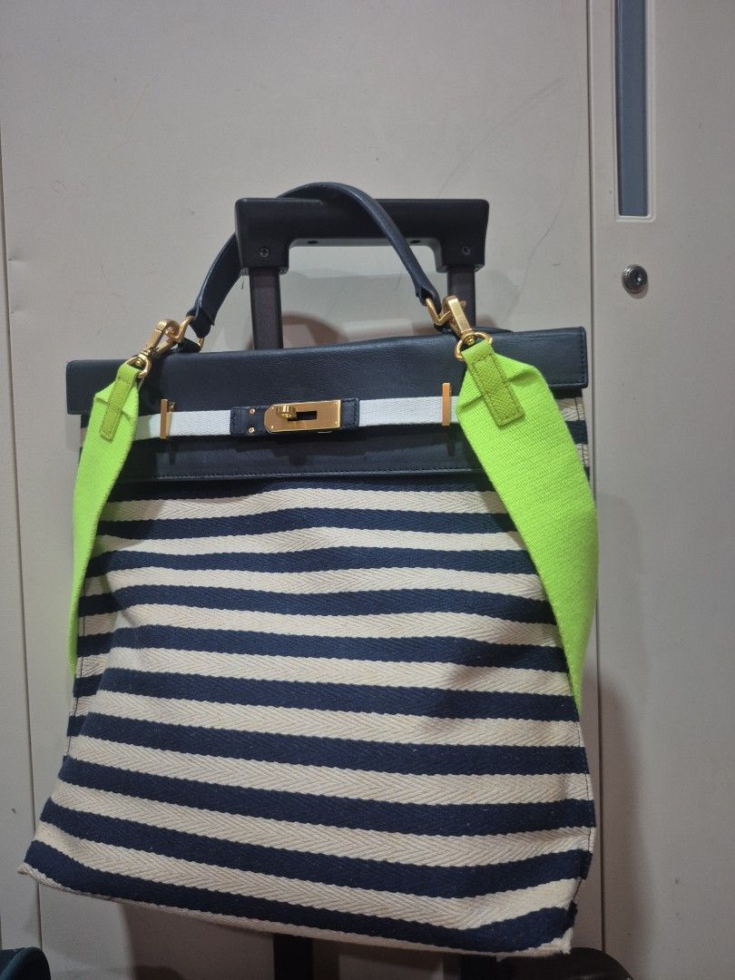 Under 82 Blue and White Striped Handbag with Neon Strap (Category: Tote Bags) located in Iloilo. Submitted by gorgeoustatz (Listing ID 1470278565, Image 1). Description: -GOOD AS NEW!!! Navy blue and cream striped canvas with dark blue leather trim - Elegant gold-tone hardware closure on front flap - Dual dark blue top handles for hand carry - Includes a trendy, bright neon green adjustable crossbody strap - Roomy everyday tote design, perfect fo