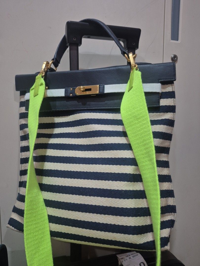 Under 82 Blue and White Striped Handbag with Neon Strap (Category: Tote Bags) located in Iloilo. Submitted by gorgeoustatz (Listing ID 1470278565, Image 2). Description: -GOOD AS NEW!!! Navy blue and cream striped canvas with dark blue leather trim - Elegant gold-tone hardware closure on front flap - Dual dark blue top handles for hand carry - Includes a trendy, bright neon green adjustable crossbody strap - Roomy everyday tote design, perfect fo