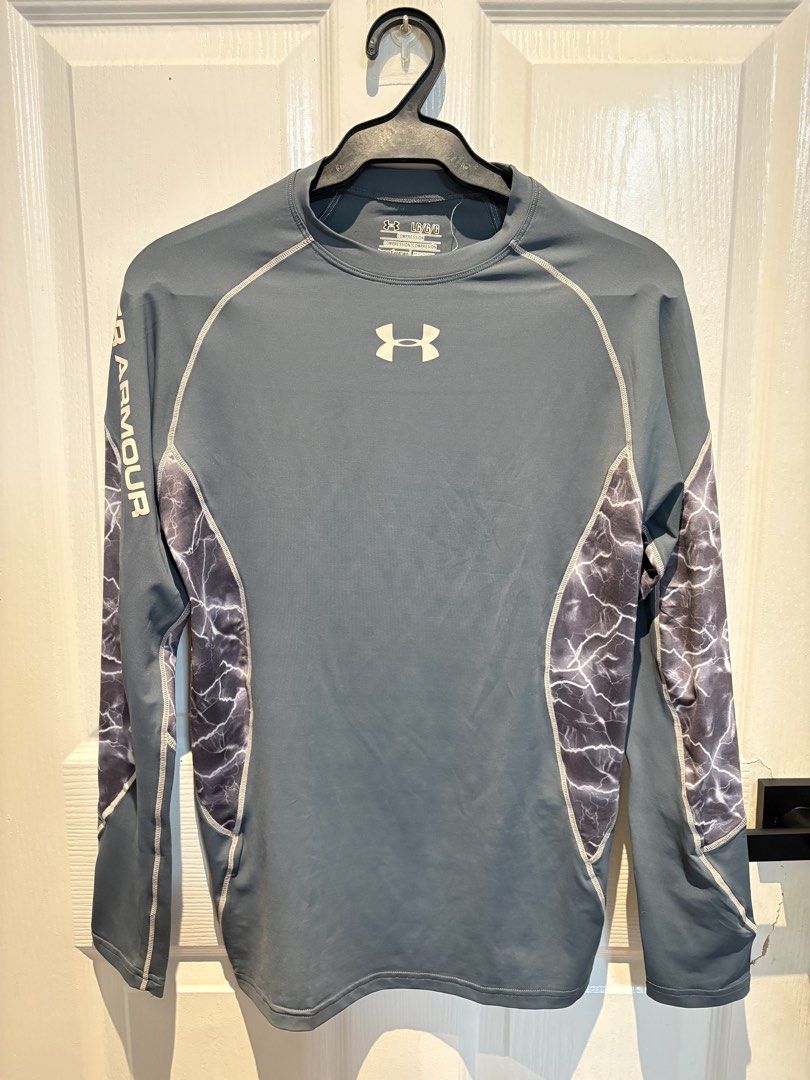 Under Armour Compression Long Sleeve Shirt Gray Lightning Print Size L (Category: Activewear) located in Taguig. Submitted by chimmy_p (Listing ID 1470280404, Image 1). Description: - Brand: Under Armour - Size: LG (Large) - Color: Gray with white logo and branding - Design: Stylish lightning graphic panels on sides and sleeves with vertical arm branding - Material: Super stretchy, high-performance fabric - Condition: Great athletic base layer, p