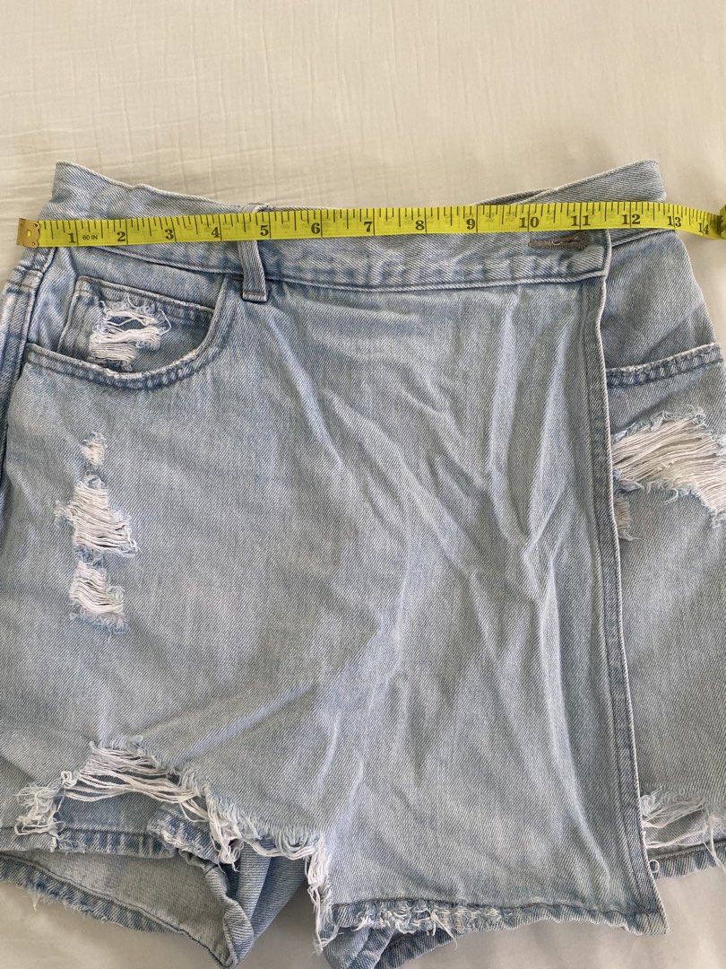 Uniqlo Distressed Denim Skort Size 24 (Category: Skirts) located in Calamba. Submitted by aninmilo (Listing ID 1470189876, Image 3). Description: - Brand: Uniqlo - Item: Distressed denim skort - Color: Light blue wash - Size: 24 (61cm waist) - Material: 100% cotton - Design: Wrap front with raw hem and ripped accents - Measurements: ~14 inches across the waist, ~14.5 inches in length - Condition: Great everyday piece.