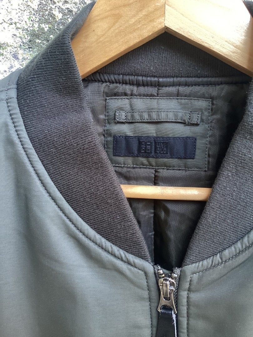 Uniqlo Olive Green Bomber Jacket MA-1 (Category: Coats, Jackets and Outerwear) located in Mangaldan. Submitted by manuelingalla_3rd (Listing ID 1470322459, Image 2). Description: - Brand: Uniqlo - Color: Classic Olive Green - Fit/Style: Bomber jacket with ribbed collar, cuffs, and hem - Pockets: Functional zip utility pocket on the left sleeve + two side pockets - Closure: Full front zipper - Interior: Warm quilted lining - Condition: Great for e