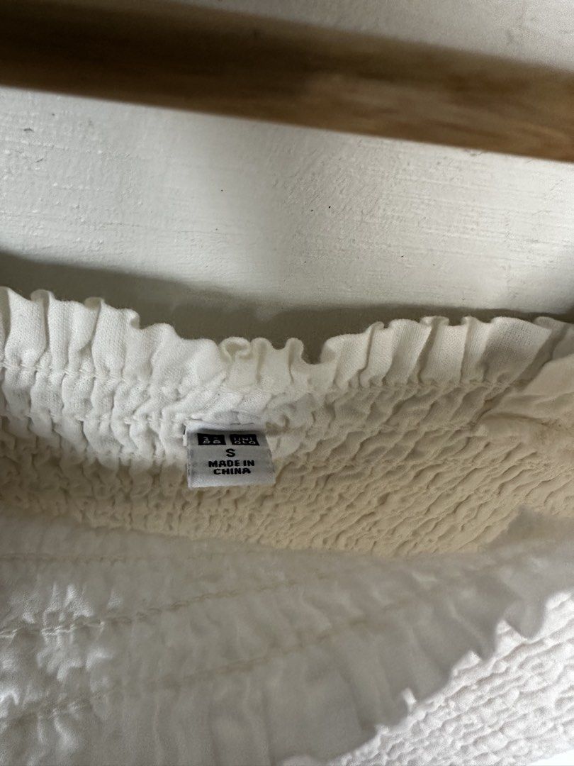 Uniqlo White Shirred Top (Category: Sleeveless) located in Manila. Submitted by omelette.12 (Listing ID 1470244410, Image 3). Description: - Brand: Uniqlo - Size: S - Color: White - Material: 100% cotton body (lightweight and breathable) - Design: Stretchy smocked body with cute ruffle straps and hem - Condition/Fit: Super comfy for warm weather, easy to match with high-waisted jeans or skirts.
