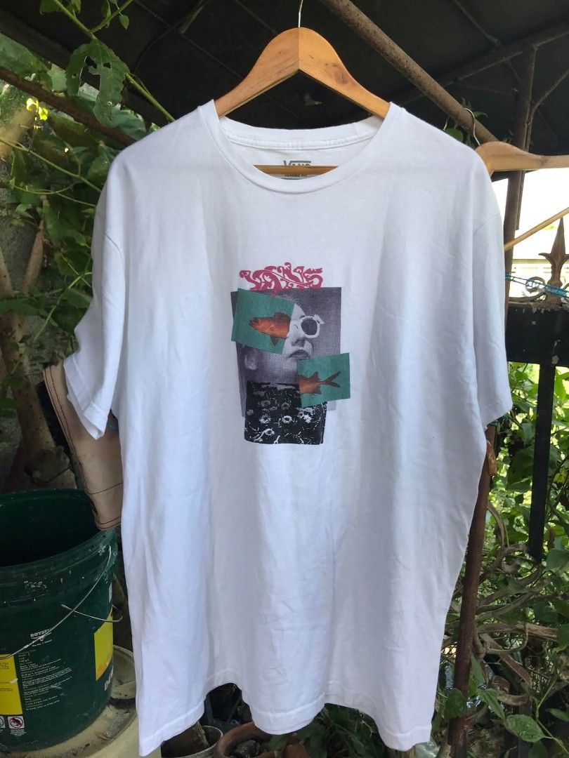 Vans Classic Fit Graphic Tee White Size L (Category: Tshirts & Polo Shirts ) located in Camiling. Submitted by akosiano (Listing ID 1470156886, Image 1). Description: - Brand: Vans - Size: Large - Color: White - Material: 100% Cotton (Made in Mexico) - Design: Front collage graphic with face and fish elements, plus sleeve logo tag - Fit/Style: Classic fit, crew neck, short sleeves - Condition: Excellent, comfortable everyday tee.