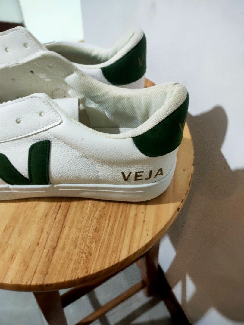 Veja White and Green Sneakers (Category: Sneakers) located in Bacoor. Submitted by mc_sells17 (Listing ID 1470342958, Image 2). Description: - Brand: Veja sneakers - Color: White with dark green heel tabs and side logos - Details: Gold foil lettering on heels and sides, white laces included - Condition: Minor yellowing and staining around collar lining and upper leather from normal wear - Soles: Clean with plenty of life left - Style: Timeless ev