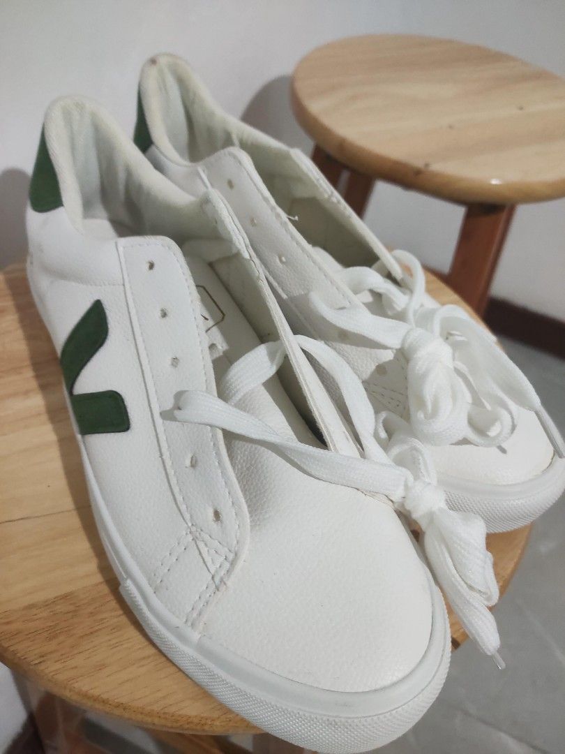 Veja White and Green Sneakers (Category: Sneakers) located in Bacoor. Submitted by mc_sells17 (Listing ID 1470342958, Image 3). Description: - Brand: Veja sneakers - Color: White with dark green heel tabs and side logos - Details: Gold foil lettering on heels and sides, white laces included - Condition: Minor yellowing and staining around collar lining and upper leather from normal wear - Soles: Clean with plenty of life left - Style: Timeless ev