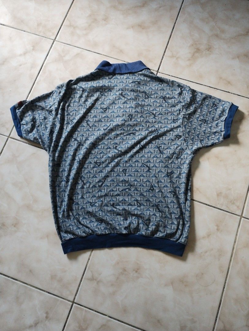 Vintage Adidas Descente Blue Patterned Polo Shirt (Category: Tshirts & Polo Shirts ) located in Imus. Submitted by darylg88358770 (Listing ID 1470156889, Image 2). Description: - Brand: Adidas (Made by Descente, Japan) - Style: Vintage retro sportswear polo shirt - Color/Pattern: Blue and grey patterned fabric with solid blue collar, cuffs, and hem - Features: Short sleeves and button placket neckline - Size: Tagged JASPOM 90-4 (Recommended for h