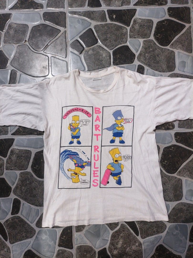 Vintage Bart Rules The Simpsons Comic Panel T-Shirt (Category: Tshirts & Polo Shirts ) located in Narvacan. Submitted by picky_looter (Listing ID 1470302647, Image 1). Description: - Color: Classic white - Size: XL - Design: Four-panel Bart Simpson comic print with 'Bart Rules', 'Underachiever', and 'Aye Carumba' text - Details: Short sleeves, crew neck, plain back - Condition: Natural fading for a vintage cartoon merch vibe.