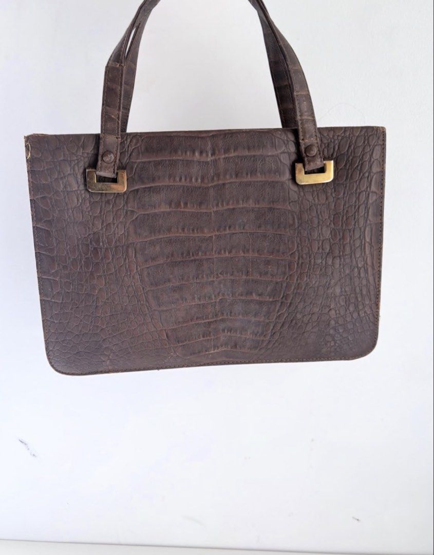 Vintage Brown Crocodile Leather Handbag (Category: Luxury Bags & Wallets) located in Calamba. Submitted by thethriftdame (Listing ID 1470245359, Image 1). Description: - Vintage brown textured crocodile leather handbag - Elegant double structured handles with gold-tone hardware - Secure double kissing lock top closure - Organized interior with multiple compartments and dark fabric lining - Includes a framed snap pocket, a zippered pocket, and an 