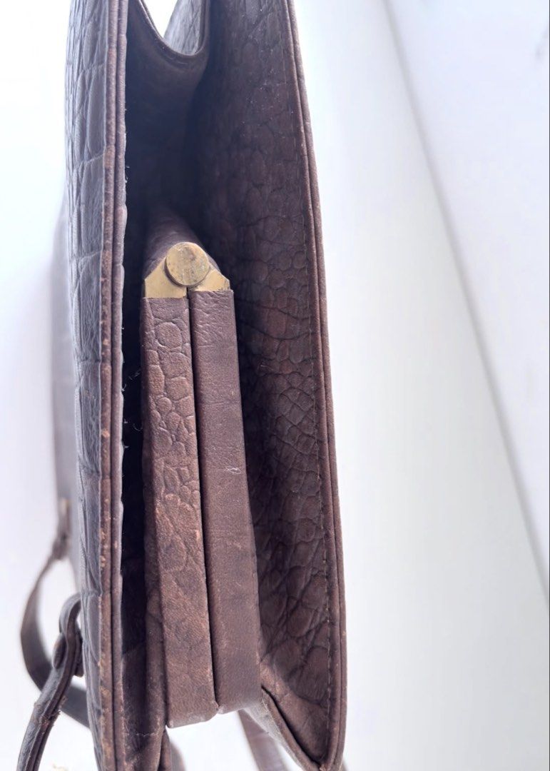 Vintage Brown Crocodile Leather Handbag (Category: Luxury Bags & Wallets) located in Calamba. Submitted by thethriftdame (Listing ID 1470245359, Image 3). Description: - Vintage brown textured crocodile leather handbag - Elegant double structured handles with gold-tone hardware - Secure double kissing lock top closure - Organized interior with multiple compartments and dark fabric lining - Includes a framed snap pocket, a zippered pocket, and an 