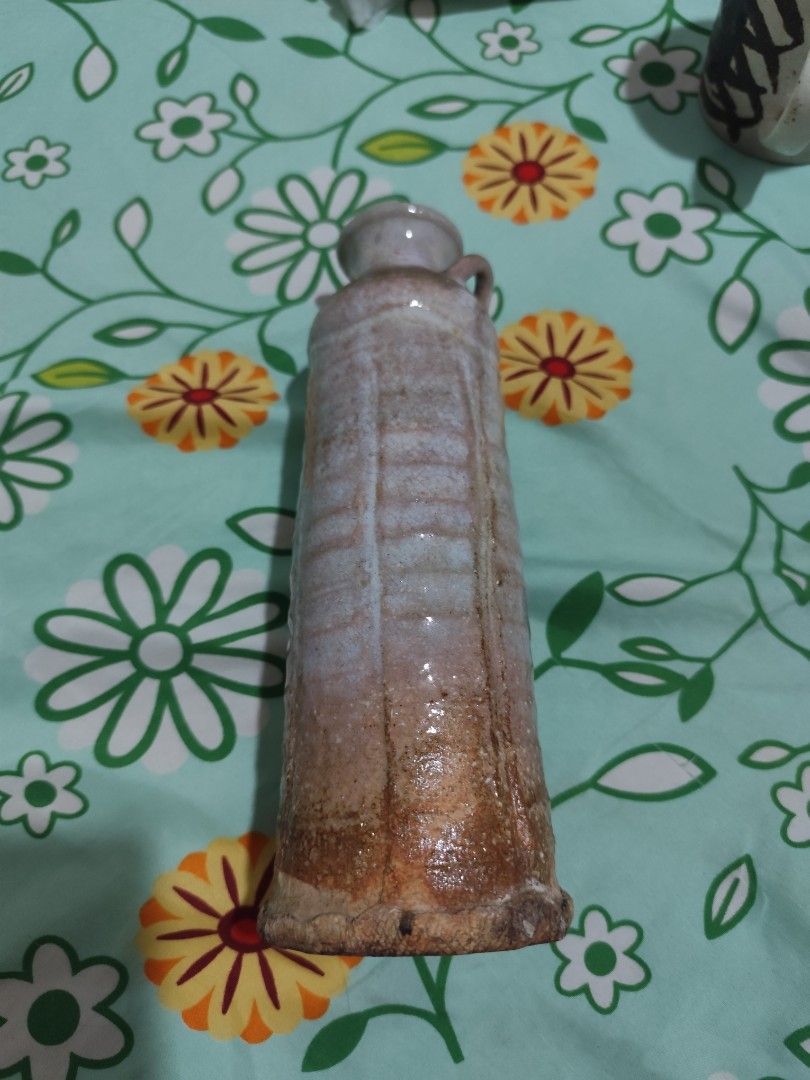 Vintage Ceramic Bud Vase with Handles (Category: Vases & Decorative Bowls) located in Manila. Submitted by marriage031073advocate (Listing ID 1470205156, Image 2). Description: - Type: Tall ceramic bud vase with two small side handles - Design: Textured ribbed vertical pattern with a flat rim - Color/Finish: Beautiful glaze shifting from grey-blue at the top to rustic brown at the base - Build: Solid, heavy-duty construction with earthy tones - C