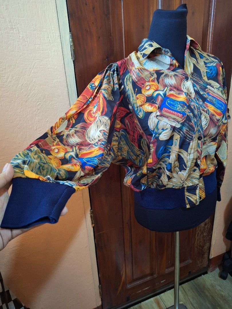 Vintage Multicolour Food Print Bomber Jacket (Category: Coats, Jackets and Outerwear) located in Balamban. Submitted by ubethan (Listing ID 1470213019, Image 2). Description: - Bold all-over print featuring jars of cocktails, vegetables, and fruit - Lightweight and smooth fabric for comfortable wear - Classic collar with a button-up front closure - Dark blue ribbed cuffs and hem for a stylish finish - Eye-catching statement piece to elevate your 
