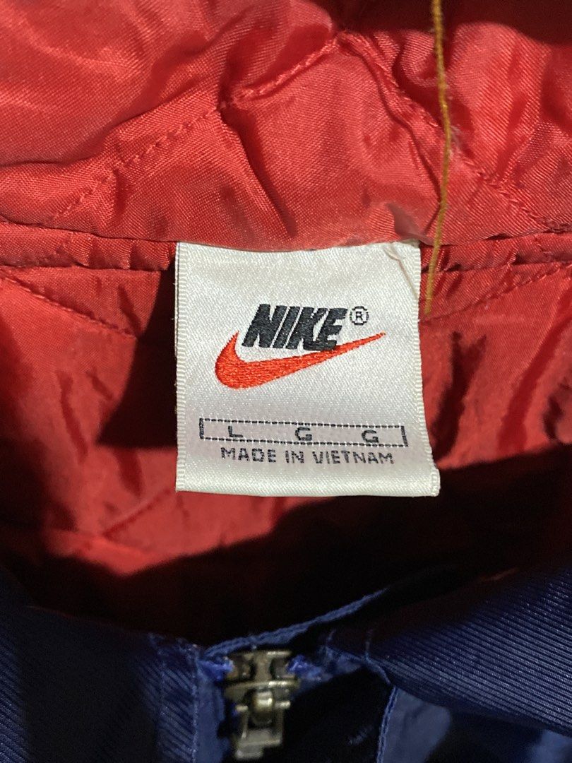 Vintage Nike Blue Red Windbreaker Jacket Size L (Category: Coats, Jackets and Outerwear) located in Caloocan City. Submitted by camarcenin42067 (Listing ID 1470279043, Image 3). Description: - Brand/Model: Nike Blue Windbreaker Jacket - Size: Large - Origin: Made in Vietnam - Color/Design: Blue exterior with a contrasting red quilted inner lining - Features: Snap button closure, drawstring hood, dual front pockets, and red ribbed cuffs - Branding