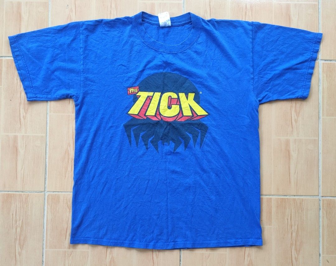 Vintage The Tick 2004 Graphic T-Shirt Blue Size L (Category: Tshirts & Polo Shirts ) located in Manila. Submitted by janablanks77380 (Listing ID 1470166708, Image 1). Description: - Official 2004 Benjamin Edlund The Tick graphic tee - Brand: Gildan Ultra Cotton tag, size Large 22 x 27.5 - Material: 100% preshrunk cotton for comfort - Color: Vibrant royal blue - Fit: Classic short sleeve, regular fit - Condition: Screen print shows minor vintage w