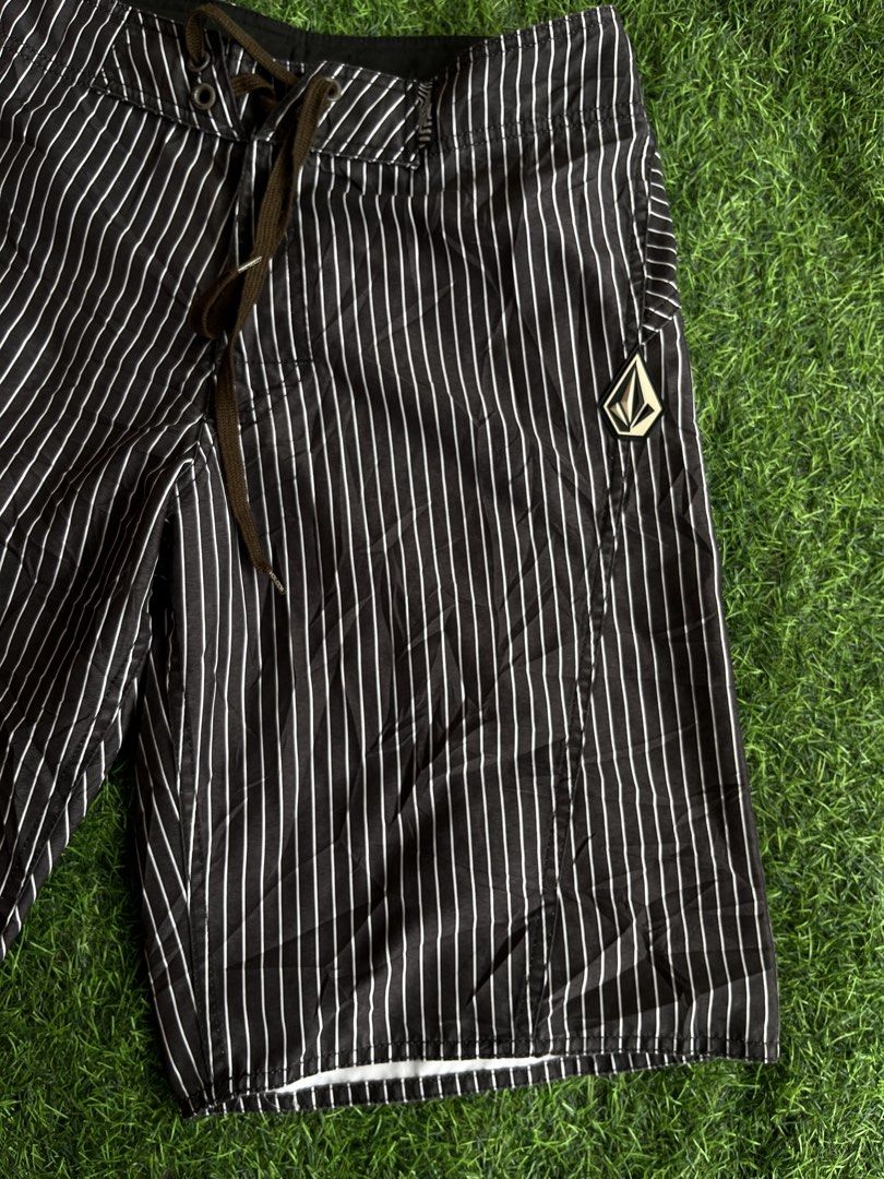 Volcom Pinstripe Board Shorts (Category: Swim Trunks & Board Shorts) located in Cebu City. Submitted by pick2zeroo (Listing ID 1470327762, Image 3). Description: - Brand: Volcom - Color: Black with white pinstripes - Features: Side cargo pocket and secure drawstring waist - Details: Iconic Volcom stone logo patch on the left leg - Material: Lightweight, perfect for swimming or casual beach days - Condition: Clean overall with no major flaws.