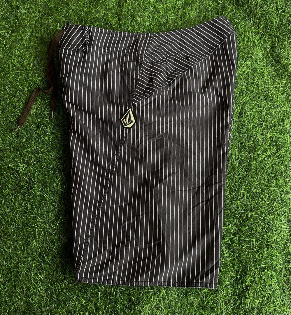 Volcom Pinstripe Board Shorts (Category: Swim Trunks & Board Shorts) located in Cebu City. Submitted by pick2zeroo (Listing ID 1470327762, Image 1). Description: - Brand: Volcom - Color: Black with white pinstripes - Features: Side cargo pocket and secure drawstring waist - Details: Iconic Volcom stone logo patch on the left leg - Material: Lightweight, perfect for swimming or casual beach days - Condition: Clean overall with no major flaws.