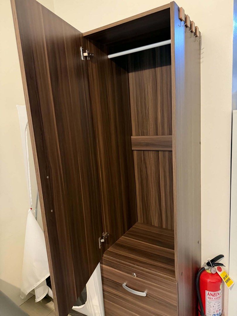 Wardrobe Cabinet with Drawers (Category: Shelves, Cabinets & Racks) located in Mandaluyong City. Submitted by artyreal (Listing ID 1470246322, Image 3). Description: - Dark wood grain finish - 1 hanging compartment with top shelf - 2 spacious lower drawers - Built-in lock on top drawer for security - Sleek silver-toned metal handles - Sturdy wooden construction - Compact size, ideal for small spaces.