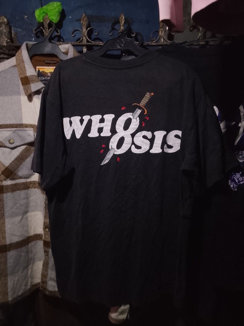 WH8OSIS Devil Graphic Black T-Shirt (Category: Tshirts & Polo Shirts ) located in Manila. Submitted by warmcloud-06f3 (Listing ID 1470217063, Image 2). Description: - Brand: WH8OSIS - Color: Black - Fit: Standard fit, crew neck - Front Design: Red devil typing on a laptop with yellow smoke and text - Back Design: Large white brand lettering pierced by a bloody dagger - Condition: Pre-owned with regular fabric wear; graphic prints are fully intact