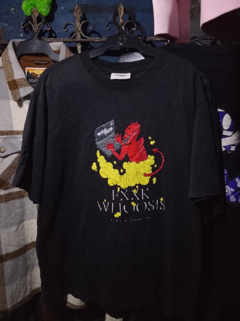 WH8OSIS Devil Graphic Black T-Shirt (Category: Tshirts & Polo Shirts ) located in Manila. Submitted by warmcloud-06f3 (Listing ID 1470217063, Image 1). Description: - Brand: WH8OSIS - Color: Black - Fit: Standard fit, crew neck - Front Design: Red devil typing on a laptop with yellow smoke and text - Back Design: Large white brand lettering pierced by a bloody dagger - Condition: Pre-owned with regular fabric wear; graphic prints are fully intact