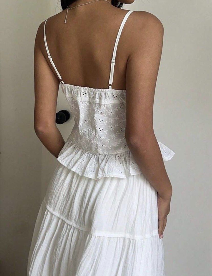 White Eyelet Button Front Camisole Tank Top (Category: Sleeveless) located in Manila. Submitted by angelyelsha (Listing ID 1470155342, Image 2). Description: - Style: Sweet white eyelet crop top with floral cutouts - Design: Sweetheart neckline with front buttons and tie knot detail - Fit: Comfortable smocked back panel and thin adjustable straps - Details: Flattering peplum ruffled hem at the bottom - Versatility: Perfect summer piece to pair wi