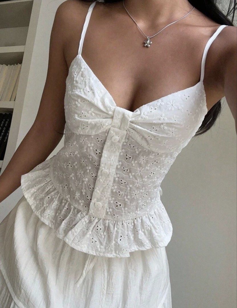 White Eyelet Button Front Camisole Tank Top (Category: Sleeveless) located in Manila. Submitted by angelyelsha (Listing ID 1470155342, Image 1). Description: - Style: Sweet white eyelet crop top with floral cutouts - Design: Sweetheart neckline with front buttons and tie knot detail - Fit: Comfortable smocked back panel and thin adjustable straps - Details: Flattering peplum ruffled hem at the bottom - Versatility: Perfect summer piece to pair wi