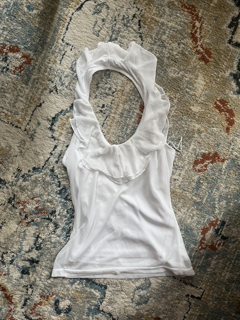 White halter top with ruffle collar (Category: Sleeveless) located in Pasay City. Submitted by robinesbin (Listing ID 1470203393, Image 1). Description: - Style super in rn!! - Material: Lightweight sheer mesh fabric with lining underneath - Condition: Brand new never used.