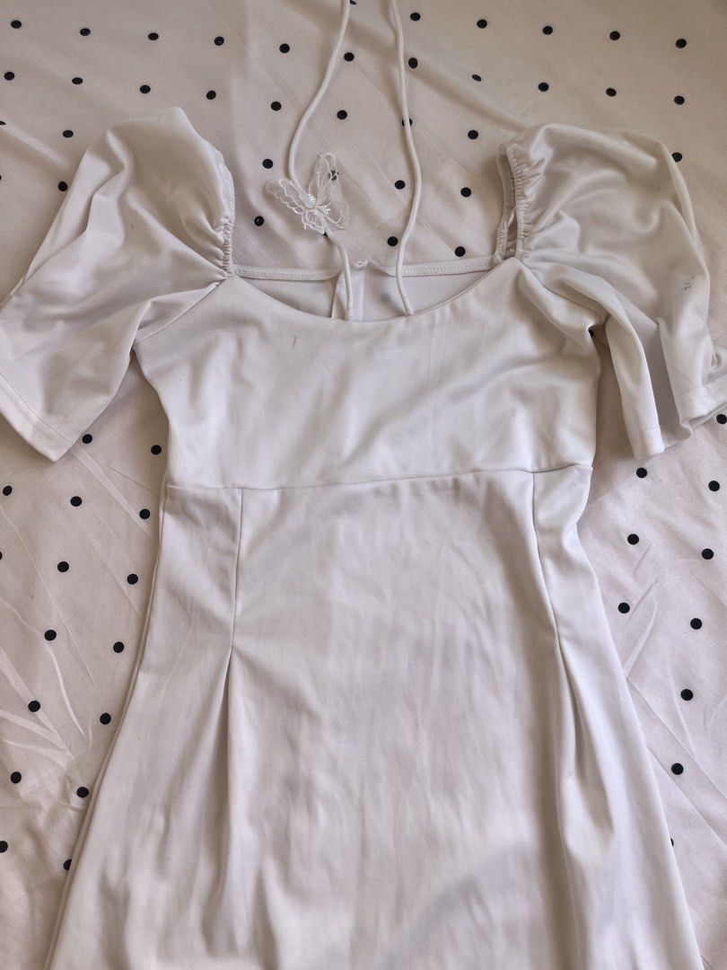White midi dress puff sleeves halter neck (Category: Dresses) located in Manila. Submitted by chimcheese (Listing ID 1470154366, Image 2). Description: - Color & Style: White midi dress with a fitted bodice and flared skirt - Neckline & Sleeves: Square neckline with trendy puff sleeves and delicate halter straps - Special Detail: Sheer lace butterfly accent at the back - Fabric: Soft, stretchy, and comfortable material - Length: Midi length (hits
