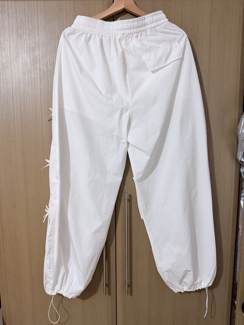 White parachute pants with bow details size XL (Category: Jeans) located in Taguig. Submitted by mengxir20193848 (Listing ID 1470250751, Image 2). Description: - Size: XL (Tag: 170/76A) - Color: White - Material: Lightweight nylon - Waist: Elastic waistband with adjustable drawstring - Cuffs: Elastic ankles with drawstrings - Details: Cute little bows sewn along the sides, plus a convenient right back pocket - Style: Super comfy and perfect for c
