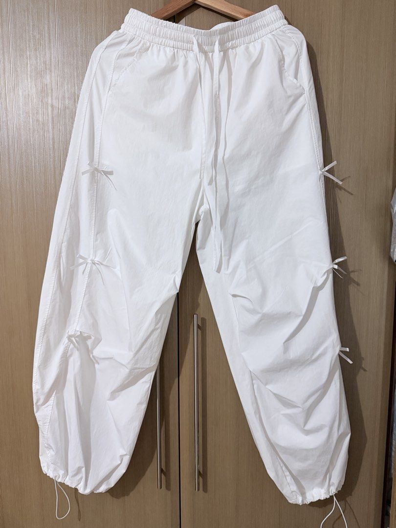White parachute pants with bow details size XL (Category: Jeans) located in Taguig. Submitted by mengxir20193848 (Listing ID 1470250751, Image 1). Description: - Size: XL (Tag: 170/76A) - Color: White - Material: Lightweight nylon - Waist: Elastic waistband with adjustable drawstring - Cuffs: Elastic ankles with drawstrings - Details: Cute little bows sewn along the sides, plus a convenient right back pocket - Style: Super comfy and perfect for c