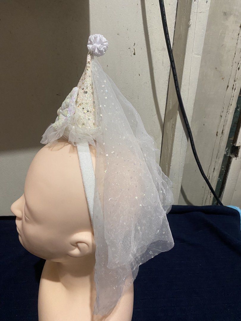 White Party Hat Headband with Veil (Category: Hair Accessories) located in Manila. Submitted by resi.diaz (Listing ID 1470324470, Image 2). Description: White headband with a sparkly cone hat and attached tulle veil. Features iridescent sequins on the hat and bow, pearls along the base, and a small pom-pom at the tip. Comfortable white fabric band..