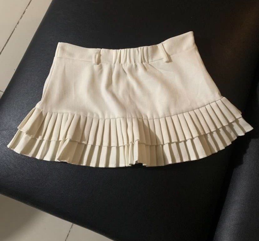 White Pleated Skirt with Inner Shorts (Category: Skirts) located in Muntinlupa City. Submitted by clophilia (Listing ID 1470257400, Image 2). Description: - Color: White - Size: 27-28 (garterized at the back) - Style: High waist layered pleated skirt with built-in shorts (skort) - Details: Belt loops, elastic back, double-layer ruffle pleats at the hem - Condition: Excellent, clean with no flaws - Perfect for: Casual everyday wear and styling.