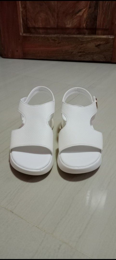 White Sandals (Category: Flats & Sandals) located in Mangaldan. Submitted by closetqwin (Listing ID 1470199770, Image 3). Description: - Color: Clean white - See 2nd picture for measurements - Material: Synthetic leather upper - Design: Chunky platform sole with a comfortable wedge heel - Closure: Gold-tone buckle on the ankle strap - Styling: Versatile design that matches shorts, jeans, and summer dresses.