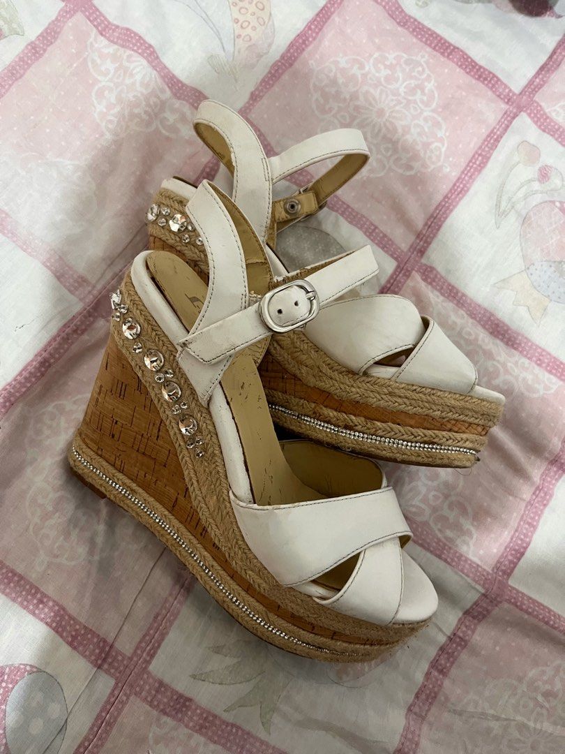 White Wedge Sandals with Rhinestone and Cork Platform (Category: Flats & Sandals) located in Manila. Submitted by brightwind_62659f (Listing ID 1470249221, Image 2). Description: - Style: White platform sandals with a high cork wedge heel - Bling: Rhinestone embellishments on the back heel and silver rhinestone chain trim along the platform - Closure: Adjustable ankle buckle strap - Condition: Minor scuffs and wear marks on the inner sole and str